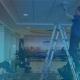 SupraNet male employee installing access point at Dane County Regional Airport. Another man unpacking APs, and another testing them.