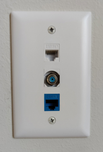 Internet wall jack with two ports and cable port in middle.