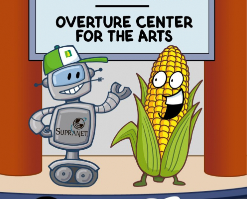 Robot in farmer's hat, life size ear of corn, on stage. SupraNet Supports the Arts, Overture Center for the Arts.