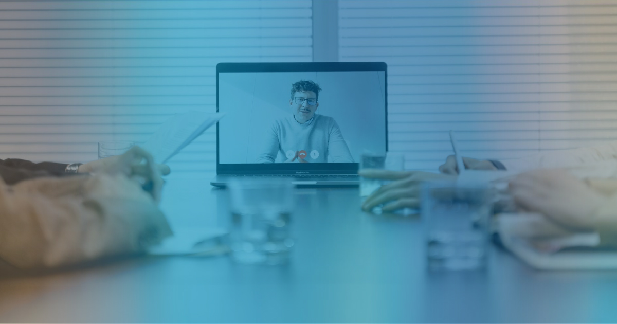 Person on screen at board table