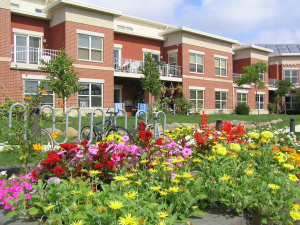 Brick apartment building with prairie flowers in front