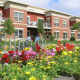 Brick apartment building with prairie flowers in front