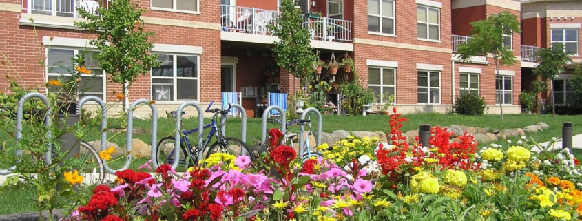 Brick apartment building with prairie flowers in front